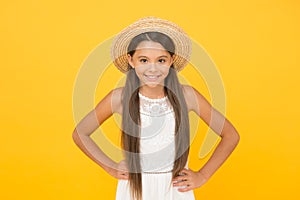 Hello. cheerful little girl wear straw hat. beach fashion for kids. small child on yellow background. holiday joy and