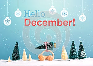 Hello December message with car carrying a Christmas tree