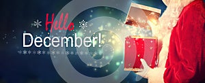 Hello December message with Santa opening a gift box
