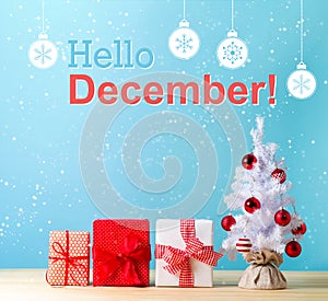 Hello December message with a Christmas tree and gift boxes