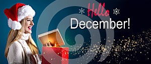 Hello December message with woman opening a gift box