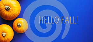Hello fall message with autumn pumpkin on a blue background