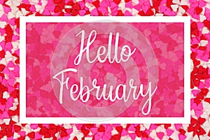 Hello February greeting card with white text over a candy heart background photo