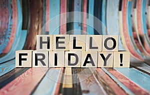 HELLO FRIDAY written on wooden blocks and set against a beautiful vibrant striped background