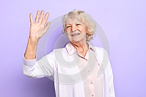 Hello Happy stylish old woman raising her hand