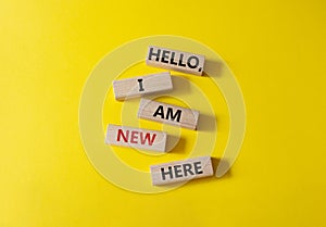 Hello I am new here symbol. Concept words Hello I am new here on wooden blocks. Beautiful yellow background. Business and Hello I