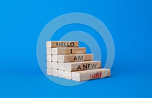 Hello I am a new hire symbol. Concept words Hello I am a new hire on wooden blocks. Beautiful blue background. Business and Hello