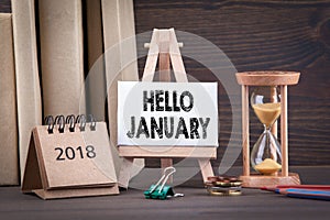 Hello january. Sandglass, hourglass or egg timer on wooden table