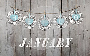 Hello january written on hanging ice blue hearts and white wooden snowflakes