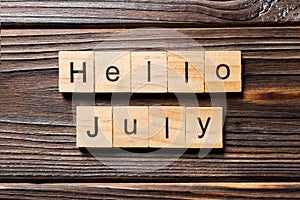 Hello july word written on wood block. hello july text on table, concept