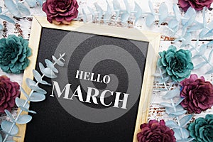 Hello March typography text and flower decoration on blackboard background