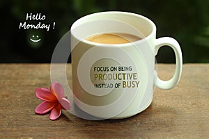 Hello Monday coffee. White mug of coffee and positive inspirational quote on it - Focus on being productive instead of busy.