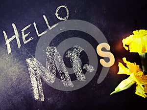 hello mr s letter written on chalkboard with yellow color flowers