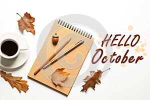 Hello October card. Flat lay composition with notebook, cup of coffee and autumn leaves on background