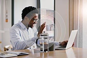 Hello from the other side. a handsome young businessman working on his laptop at home.