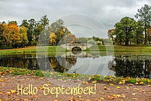 Hello September banner. New month. Greeting card. Golden autumn. The text in the photo. Trees in the park. City Park. Autumn Park