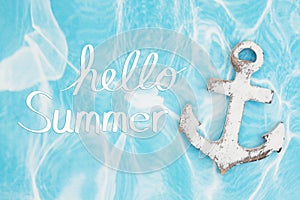 Hello Summer message with weathered anchor on a turquoise paper