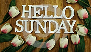 Happy sunday word alphabet letters on wooden table top view with tulip flower decoration