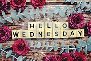 Hello Wednesday alphabet letter and flower decorate on wooden background