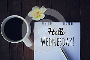 Hello Wednesday. Have a happy, beautiful and productive Wednesday concept. With morning coffee and text greeting on notepad.