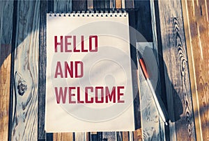 Hello and welcome symbol. Conceptual words hello and welcome on notepad and vintage background