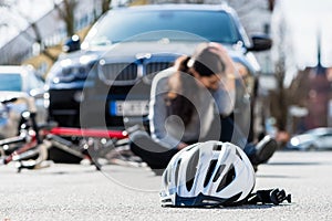 Helmet on the asphalt after accidental collision between bicycle and car