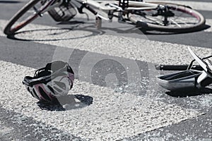 Helmet and broken cars mirror next to broken bicycle on pedestrian crossing