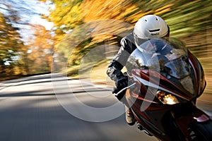 helmet in the foreground, blurry motorcycle speeding away in the background