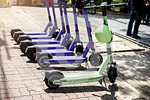 Helmet hanging on electric scooter. Electric scooters line up on the sidewalk for rent to tourists