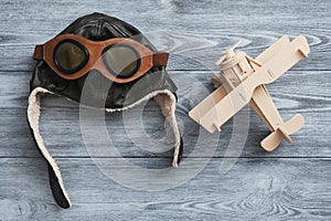 Helmet and plane on wooden background