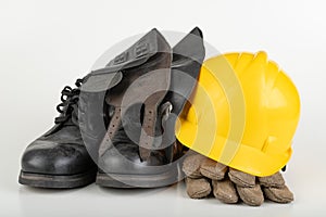 Helmet, work boots and gloves on a white table. Workwear for the production worker