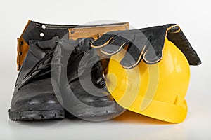 Helmet, work boots and gloves on a white table. Workwear for the production worker