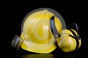 Helmet and workwear on a black working table. Accessories for co