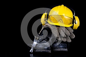 Helmet and workwear on a black working table. Accessories for co
