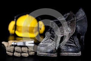 Helmet and workwear on a black working table. Accessories for co