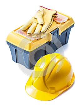 Helmet and yellow leather toolbox with gloves on it isolated