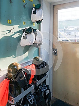 Helmets and SCBAâ€‹ hang on the wall near door for emergency case.