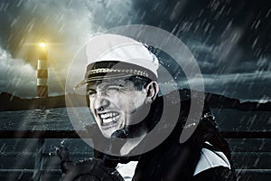 Helmsman with vest and cap struggle against storm photo