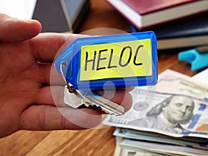 Heloc loan concept. Hand holds key as symbol of property buying