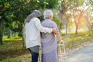 Help and care Asian senior or elderly old lady woman use walker with strong health while walking at park