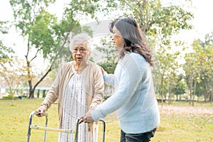 Help and care Asian senior or elderly old lady woman use walker with strong health while walking at park in holiday