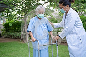 Help and care Asian senior or elderly old lady woman use walker with strong health while walking at park in happy fresh holiday