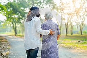 Help and care Asian senior or elderly old lady woman use walker with strong health while walking at park in happy holiday.