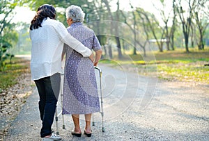 Help and care Asian senior or elderly old lady woman use walker with strong health while walking at park