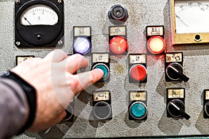 With the help of the control panel from the CNC machine, the man gives the command to the machine to process the part