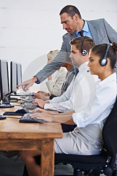 Help desk, management and row of women, men and typing on computer at customer support. Headset, telemarketing and