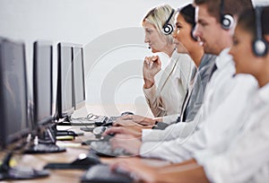 Help desk, phone call and row of women, men and typing on computer at customer support. Headset, telemarketing and
