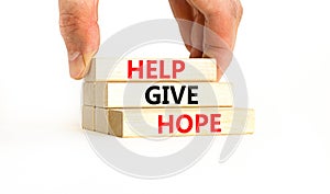 Help give hope symbol. Concept word Help give hope on beautiful wooden block. Businessman hand. Beautiful white table white