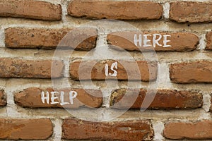 Help is here and support symbol. Concept words Help is here on brick wall. Beautiful brick wall background. Business support and