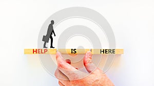 Help is here and support symbol. Concept words Help is here on wooden blocks on beautiful white table white background.